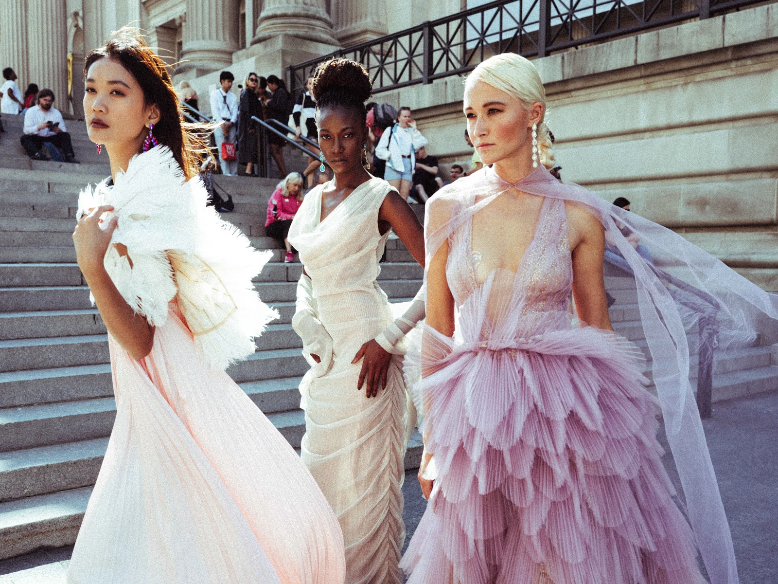 Alexis Monsanto — Three models in white and lilac gowns on museum steps