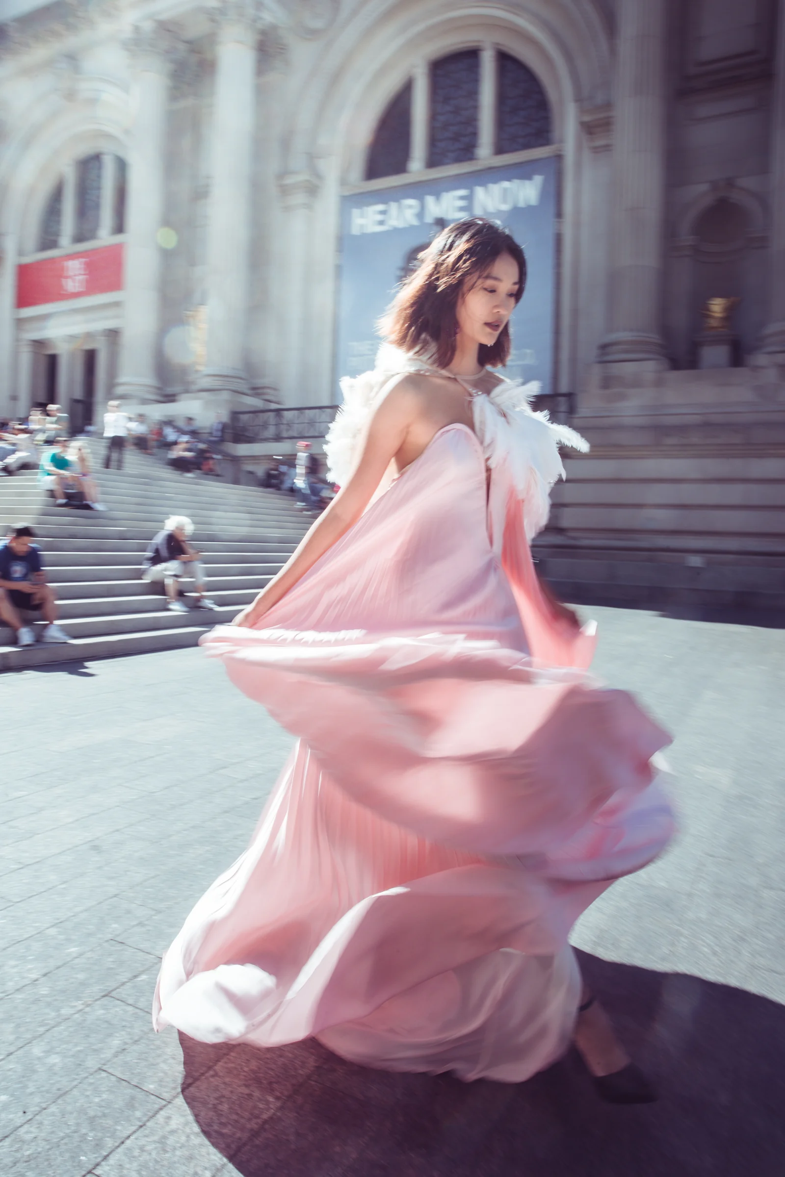 Alexis Monsanto — A model holding a flowing pink gown on outdoor steps