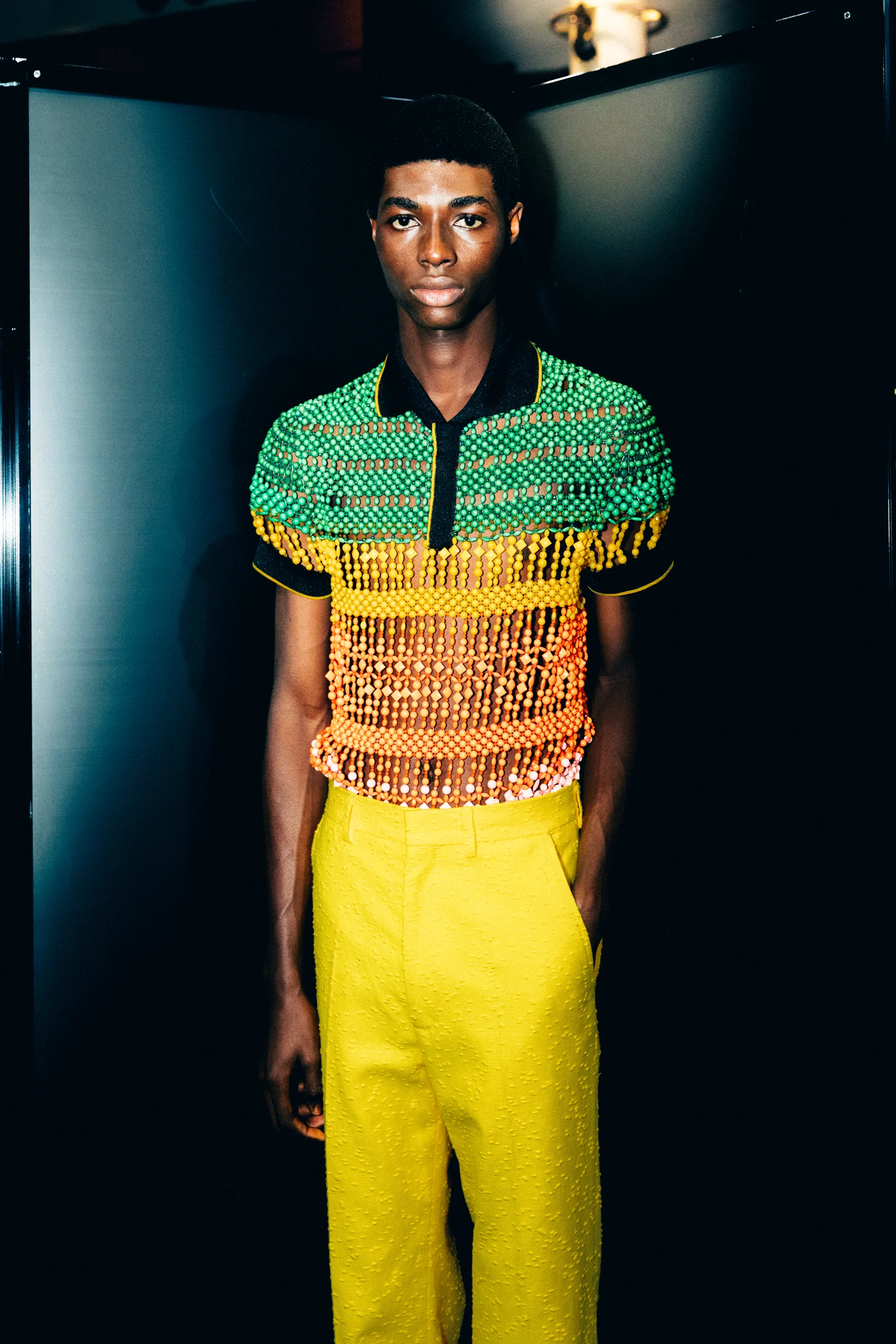 Casablanca — A model in a green and yellow knit shirt with yellow trousers
