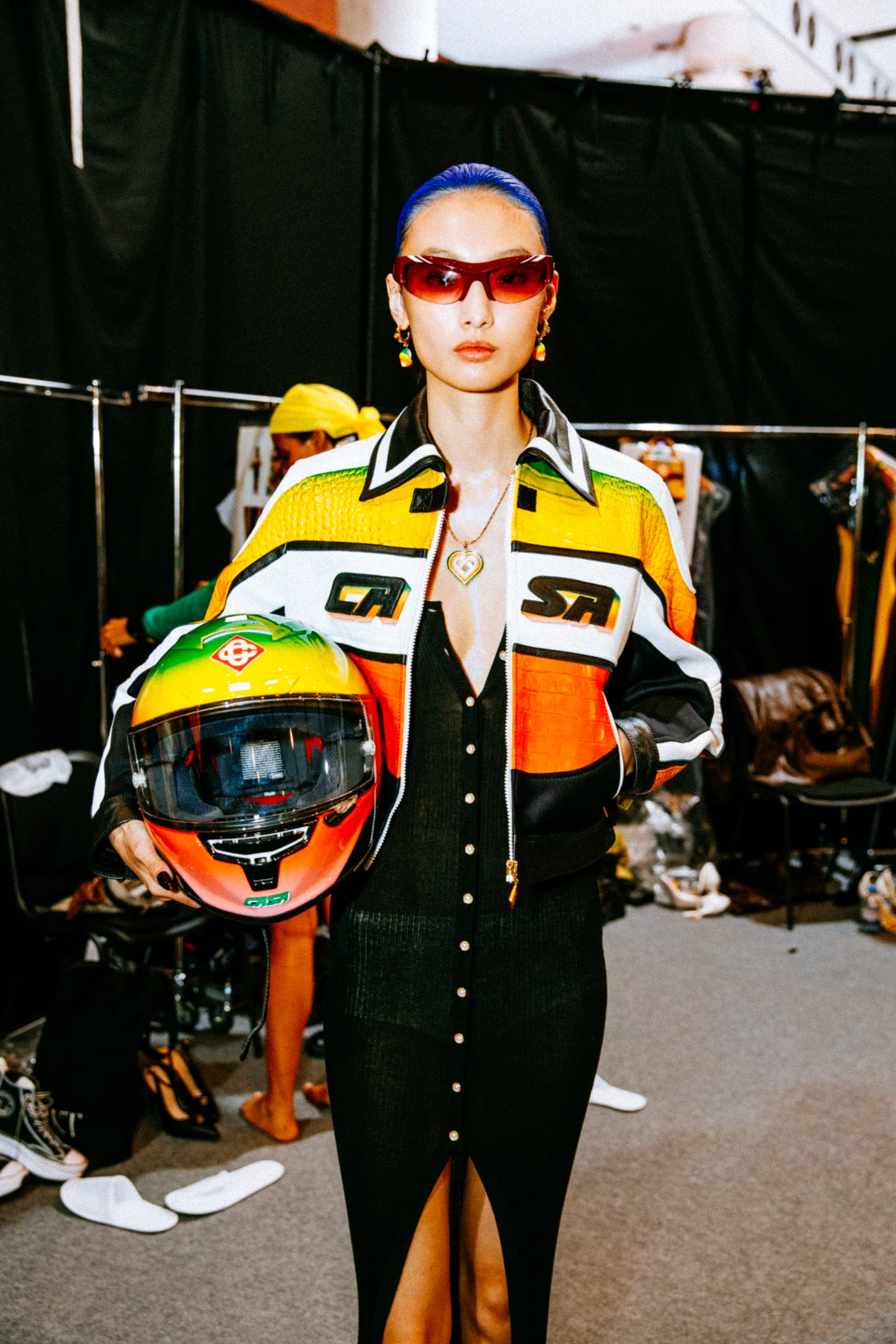 Casablanca — A model wearing a colourful jacket and holding a racing helmet