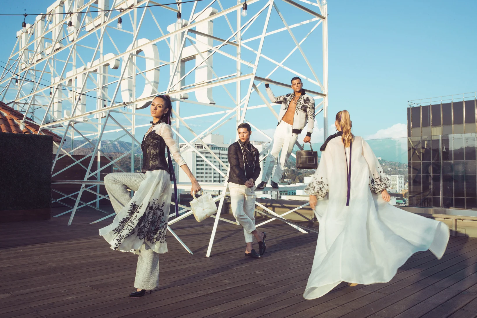Models in flowing garments on an architectural rooftop