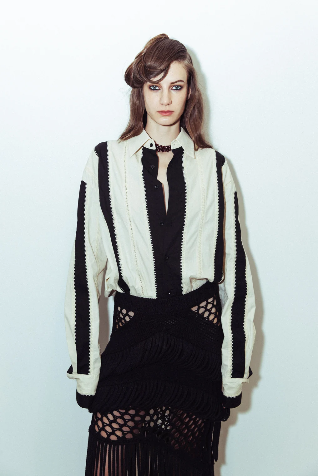 Diotima — A model in a graphic cardigan and tie