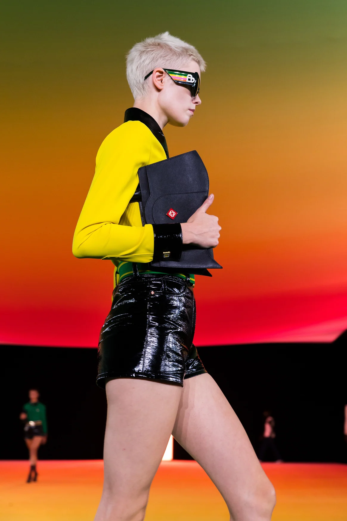 A model in sunglasses walking on a runway